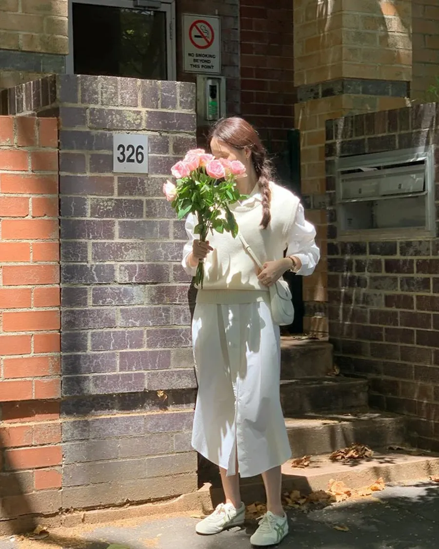 Váy sơ mi trắng kết hợp với áo gile len và sneaker trắng